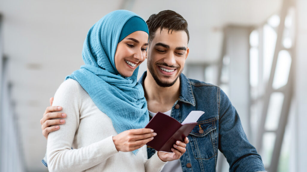 Young Islamic Spouses Waiting For Flight Boarding At Airport Terminal